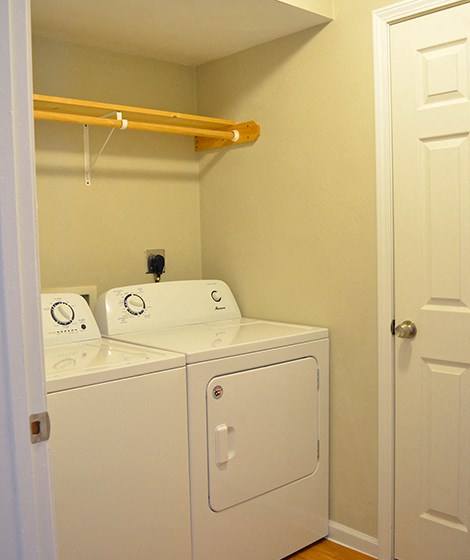 In-unit laundry room with full-size washer and dryer and hanging rack